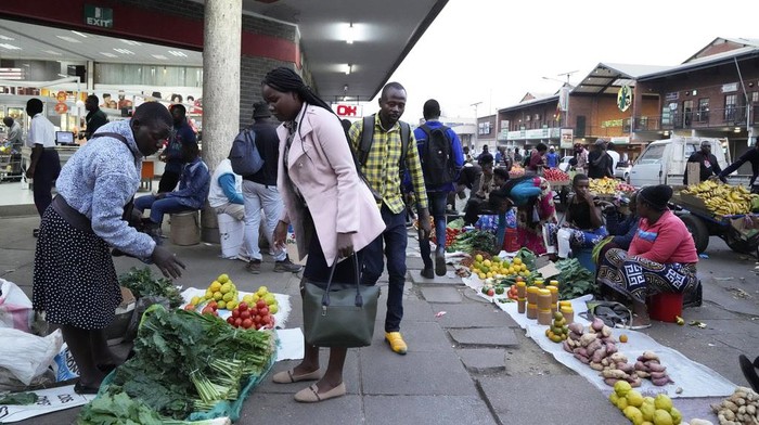 Street traders sell various goods outside a supermarket on the streets of Harare, in this Monday, May, 22, 2023 photo. Shoppers in Zimbabwe are increasingly turning to street traders to buy what they need as the local currency plunges in value against the U.S. dollar.Street traders in cars, on bicycles or on foot clog sidewalks, roads and parking spaces. They sell items ranging from groceries to cosmetics, brooms, dog chains, car parts and medicines. (AP Photo/Tsvangirayi Mukwazhi)