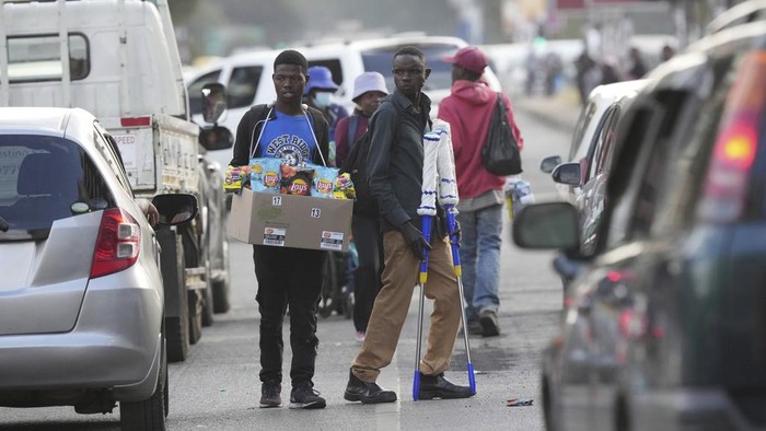 Geliat Pedagang Kaki Lima di Tengah Runtuhnya Mata Uang Zimbabwe Street traders sell various goods outside a supermarket on the streets of Harare, in this Monday, May, 22, 2023 photo. Shoppers in Zimbabwe are increasingly turning to street traders to buy what they need as the local currency plunges in value against the U.S. dollar.Street traders in cars, on bicycles or on foot clog sidewalks, roads and parking spaces. They sell items ranging from groceries to cosmetics, brooms, dog chains, car parts and medicines. (AP Photo/Tsvangirayi Mukwazhi)