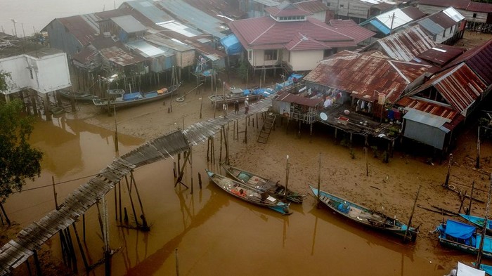 Warga berjalan di ujung jembatan yang rusak di Tanjung Solok, Tanjung Jabung Timur, Jambi, Rabu (24/5/2023). Jembatan yang dibangun dengan konstruksi panggung kayu sepanjang sekitar 300 meter di atas kawasan hutan bakau sejak belasan tahun lalu untuk menghubungkan beberapa RT di pesisir Kuala Jambi itu rusak dan tidak bisa dilewati sejak Selasa (23/5/2023) sehingga menghambat mobilitas warga. ANTARA FOTO/Wahdi Septiawan/foc.