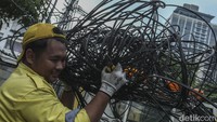 Sejumlah petugas Dinas Bina Marga memangkas kabel fiber optik di Jalan Haji Agus Salim, Jakarta, Rabu (24/5/2023).