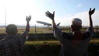 Warga melambaikan tangan pada pesawat Garuda boing 777-300 ER yang membawa 393 jamaah calon haji kloter pertama embarkasi Aceh di Bandara Internasional Sultan Iskandar Muda, Aceh Besar, Aceh, Rabu (24/5/2023). ANTARA FOTO/Irwansyah Putra