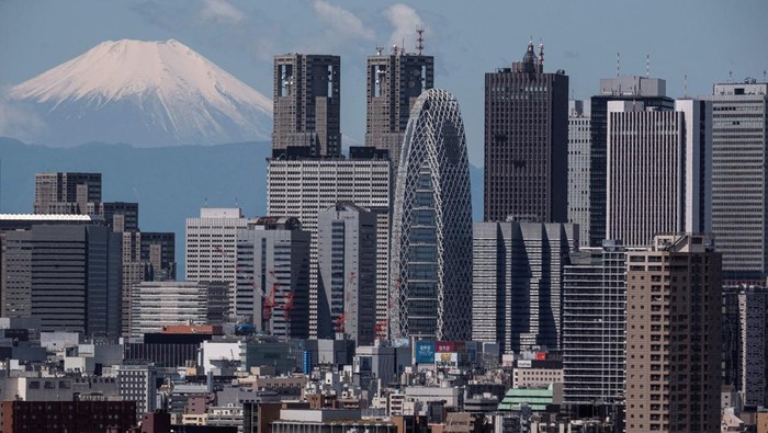 The skyscrapers of the Shinjuku area are pictured as Mount Fuji (L), Japan's highest mountain at 3,776 meters (12,389 feet), looms in the background of Tokyo on May 24, 2023. (Photo by Richard A. Brooks / AFP) (Photo by RICHARD A. BROOKS/AFP via Getty Images)