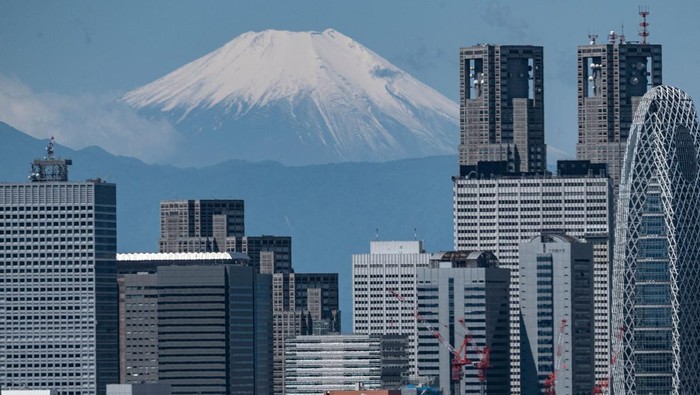 The skyscrapers of the Shinjuku area are pictured as Mount Fuji (L), Japans highest mountain at 3,776 meters (12,389 feet), looms in the background of Tokyo on May 24, 2023. (Photo by Richard A. Brooks / AFP) (Photo by RICHARD A. BROOKS/AFP via Getty Images)