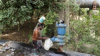 Seorang pria mandi di samping pipa air yang rusak, pada hari musim panas yang terik di New Delhi. REUTERS/Anushree Fadnavis  