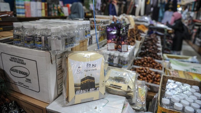 Pedagang melayani seorang pembeli di pusat penjualan oleh-oleh haji di Pasar Baru, Bandung, Jawa Barat, Rabu (24/5/2023). Pedagang menyatakan, rata-rata pedagang di pusat penjualan oleh-oleh haji dan umrah di Pasar Baru Bandung pada tahun ini mengalami peningkatan penjualan sebanyak 30 persen atau sekitar Rp30 juta perhari dibandingkan dengan tahun lalu. ANTARA FOTO/Raisan Al Farisi/foc.