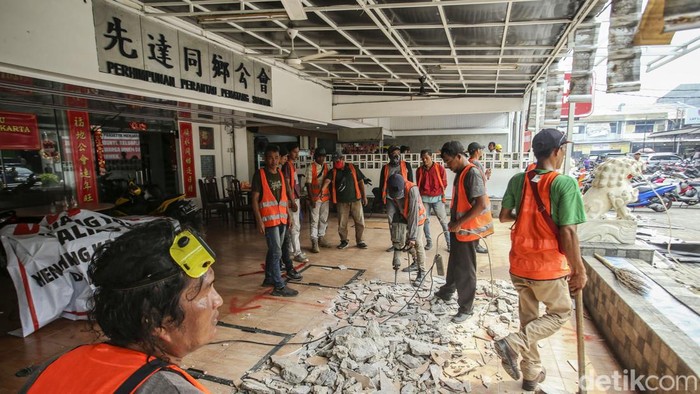 Satpol PP DKI Jakarta mulai membongkar bagian ruko di Pluit, Jakarta Utara, yang memakan badan jalan dan menutupi saluran air, Rabu (24/5/2023). Petugas Satpol PP sudah berdatangan di lokasi.