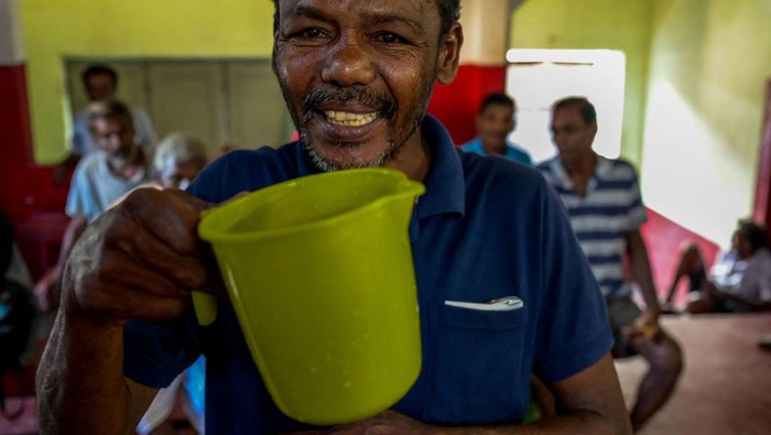 A toddy shop worker fills a vessel containing palm wine, or toddy as it is locally known, at a shop in Colombo on May 23, 2023. (Photo by Ishara S. KODIKARA / AFP) (Photo by ISHARA S. KODIKARA/AFP via Getty Images)