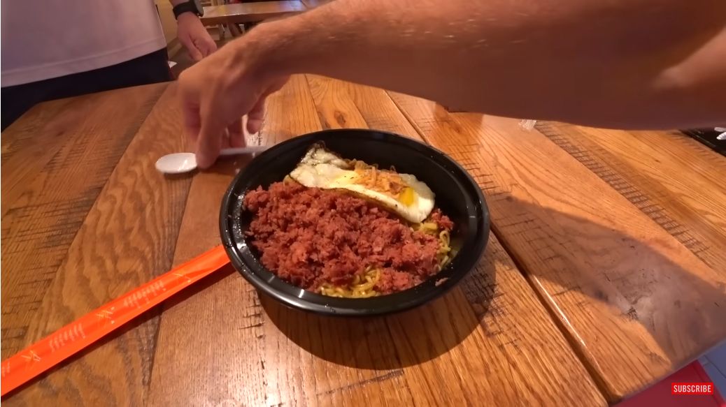 Bule mencoba Indomie goreng dengan topping kornet dan telur di warkop New York, Amerika Serikat