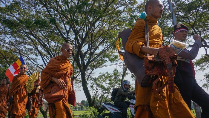 Sejumlah biksu berjalan dengan diiringi polisi, TNI, dan berbagai relawan saat mengikuti ritual Thudong di Kabupaten Pekalongan, Jawa Tengah, Kamis (25/5/2023). Sebanyak 32 biksu berjalan melewai jalan nasional Pantai Utara (Pantura) Pemalang-Pekalongan dalam ritual perjalanan Thudong dari Kota Nakhon Si Thammarat Thailand menuju Candi Borobudur dalam rangka menyambut Hari Raya Waisak pada 4 Juni 2023. ANTARA FOTO/Harviyan Perdana Putra/hp.