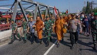Sejumlah biksu berjalan dengan diiringi polisi, TNI, dan berbagai relawan saat mengikuti ritual Thudong di Kabupaten Pekalongan, Jawa Tengah, Kamis (25/5/2023).   