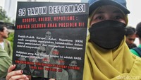 Tampak salah satu demonstran yang menunjukkan sebuah poster mengenai 25 tahun reformasi tersebut.