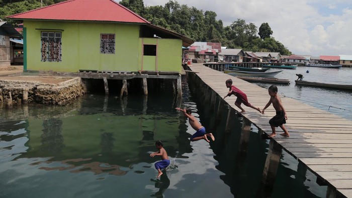Sejumlah anak suku Bajo melompat ke laut di Perkampungan Bajo Sangkuang, Pulau Bacan, Kabupaten Halmahera Selatan, Maluku Utara, Rabu (24/5/2023). Perkampungan suku Bajo yang telah dijadikan sebagai desa wisata tersebut dihuni oleh 2.350 jiwa dari 548 kepala keluarga yang sebagian besar masih tinggal di atas air dan dikenal sebagai penangkap ikan ulung. ANTARA FOTO/Andri Saputra/nym.