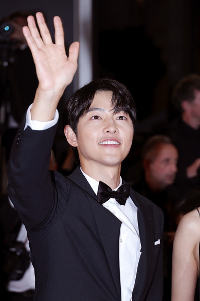 Song Joong Ki batal menggandeng istri barunya Katy Louise Saunders di Festival Film Cannes. Saat tiba di red carpet untuk pemutaran perdana filmnya, calon ayah itu memilih gaya klasik dengan memakai setelan jas hitam Louis Vuitton. Foto: Getty Images