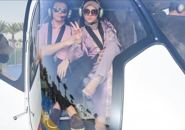 Potret saat Syahrini dan Reino berada di dalam helikopter. Kompak mengenakan baju senada, keduanya terlihat begitu menikmati liburan mereka. Foto: Instagram/@princessyahrini