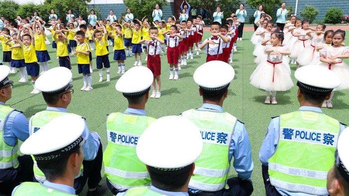 ZHANGYE, CHINA - MAY 23: Police officers watch cultural performances given by kindergarten children on May 23, 2023 in Zhangye, Gansu Province of China. Children are invited to visit a branch of Zhangye Public Security Bureau before International Children's Day. (Photo by VCG/VCG via Getty Images)