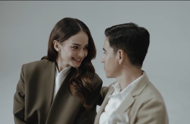 Enzy dan Molen tampil dalam beberapa gaya busana. Salah satunya dengan busana smart casual di dalam studio. Enzy tampak memakai oversized blazer dipadu blouse dan rok tutu, dan Molen mengenakan jas serta kemeja putih. Foto: Instagram/@enzystoria @derai.studio