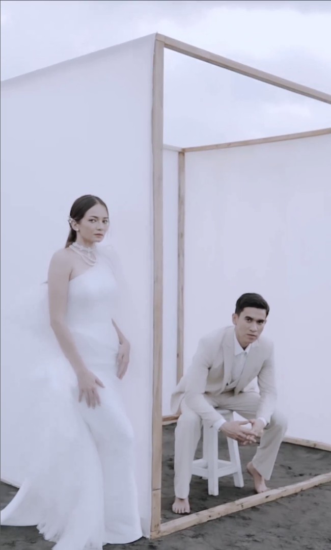 Prewedding juga dilakukan di tepi pantai. Busana keduanya tampak lebih formal dengan gaun panjang dan setelan jas. Foto: Instagram/@enzystoria @derai.studio