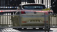 Sekitar mobil yang digunakan untuk menabrak gerbang juga dipasangi garis polisi. 
