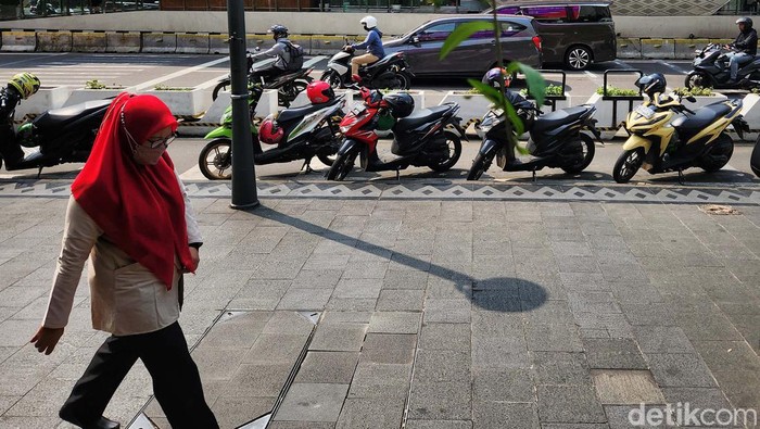 Sejumlah pengendara ojek online memarkir kendaraanya di badan jalan jalur sepeda di Jalan MH Thamrin, Jakarta, Jumat (26/5/2023). Para ojok online ini menunggu orderan di halte Bundaran HI yang merupakan titik temu Bus TransJakarta dan MRT. Parkir sembarangan ini difoto sekitar pukul 10.30 WIB.