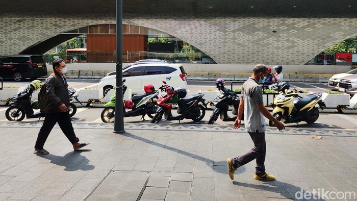 Sejumlah pengendara ojek online memarkir kendaraanya di badan jalan jalur sepeda di Jalan MH Thamrin, Jakarta, Jumat (26/5/2023). Para ojok online ini menunggu orderan di halte Bundaran HI yang merupakan titik temu Bus TransJakarta dan MRT. Parkir sembarangan ini difoto sekitar pukul 10.30 WIB.