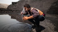 Seorang pekerja tambang mencuci wajahnya di tengah teriknya sinar matahari di tambang batu bara yang dioperasikan oleh South Eastern Coalfields Ltd. di Gevra, Chhattisgarh, India.