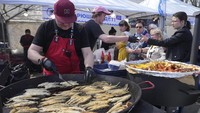 Seorang juru masak memasak ikan bau untuk dinikmati pengunjung selama festival.  