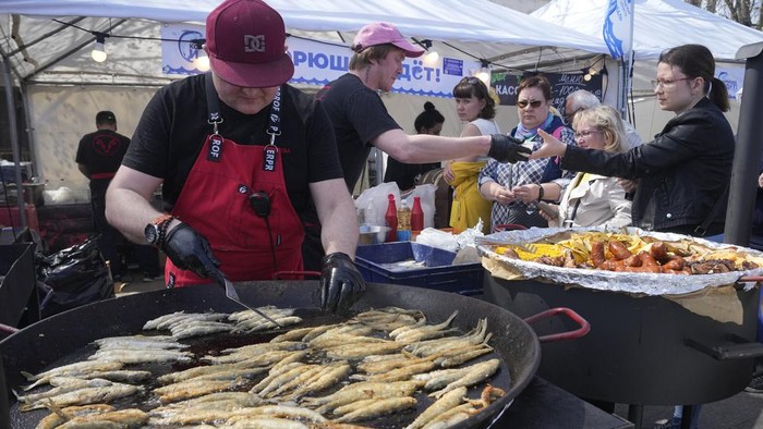 Ramai-ramai Warga Rusia Hadiri Festival Ikan Bau A cook fries smelt fish during a traditional smelt fish gastronomic festival in the city of Novaya Ladoga (New Ladoga), 125 km (77 miles) east of St. Petersburg, Russia, Saturday, May 13, 2023. In the northern Russian city Saint Petersburg smelt fish (known locally as koryushka) is known as a special local delicacy, famous for its