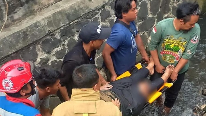 Sudin Damkar Jaksel mengevakuasi korban kecelakaan yang terpental ke kali.