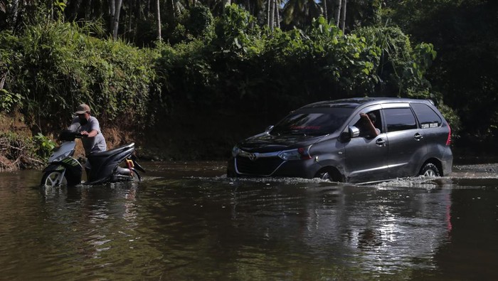 20 Tahun Tidak Ada Jembatan, Warga Terpaksa Terobos Sungai Warga mendorong sepeda motor saat menyeberangi sungai di Desa Bibinoi Pulau Bacan, Kabupaten Halmahera Selatan, Maluku Utara, Sabtu (27/5/2023). Akibat tidak ada jembatan, selama 20 tahun lebih warga di Kecamatan Bibinoi terpaksa harus menyeberangi sungai untuk melakukan aktivitas dan jika debit air sungai naik atau meluap saat musim hujan sungai tersebut tidak bisa dilalui. ANTARA FOTO/Andri Saputra/foc.