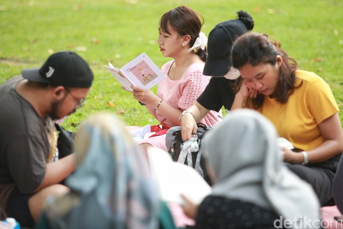 Para pegiat literasi dari komunitas Kumpul Baca membaca buku bersama di taman kota Lapangan Banteng, Jakarta. Kegiatan ini untuk menumbuhkan minat baca.