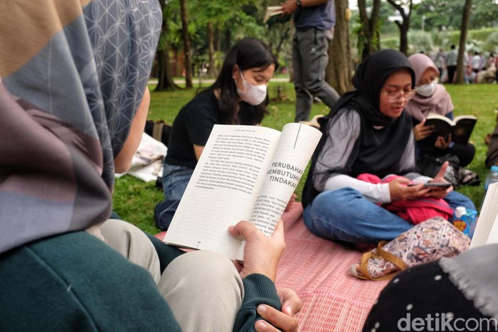 Para pegiat literasi dari komunitas Kumpul Baca membaca buku bersama di taman kota Lapangan Banteng, Jakarta. Kegiatan ini untuk menumbuhkan minat baca.