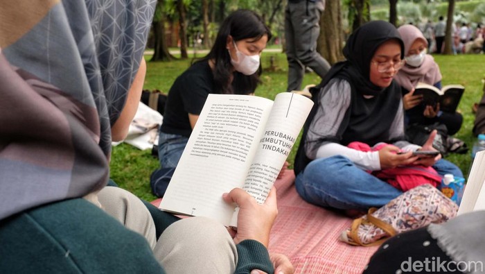 Asyiknya Baca Buku di Bawah Pohon Rindang Taman Kota Para pegiat literasi dari komunitas 'Kumpul Baca' membaca buku bersama di taman kota Lapangan Banteng, Jakarta. Kegiatan ini untuk menumbuhkan minat baca.