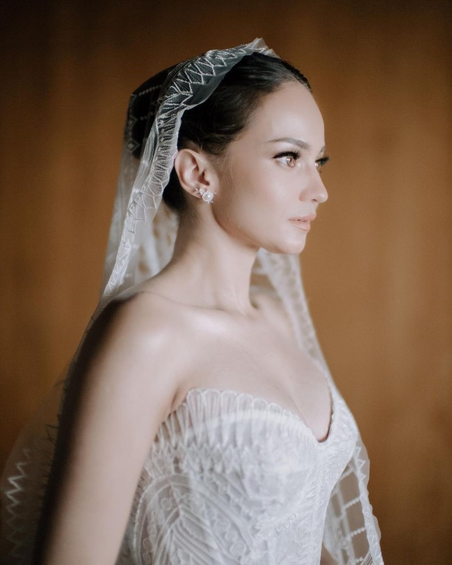 Jika di momen pernikahan sebelumnya, Enzy tampil tradisional dengan adat Minang, acara di Bali dibuat internasional. Gaun strapless dengan potongan korset mempertegas lekukan tubuh Enzy. Foto: instagram Enzy Storia