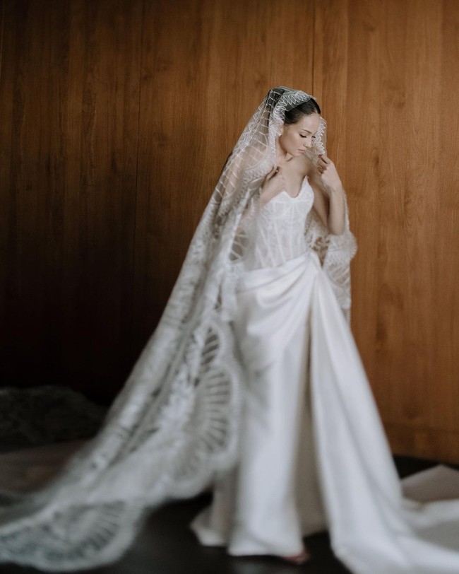 Eny pun tampil mengenakan veil berbahan lace yang semakin menambah kesan elegan. Veil tersebut dibuat sepanjang 4 meter. Foto: instagram Enzy Storia