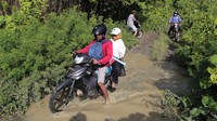 Pengendara roda dua melintasi jalan rusak di Desa Bibinoi Pulau Bacan, Kabupaten Halmahera Selatan, Maluku Utara, Sabtu (27/5/2023). 
