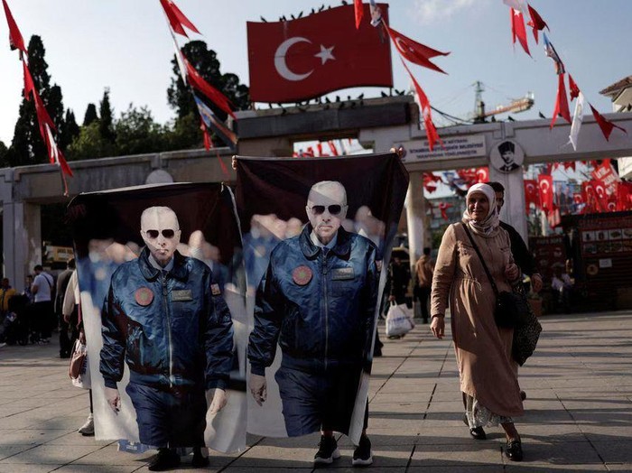 Women display flags with images of Turkish President Tayyip Erdogan next to an election campaign point, ahead of the May 28 presidential runoff vote, in Istanbul, Turkey May 25, 2023. REUTERS/Murad Sezer