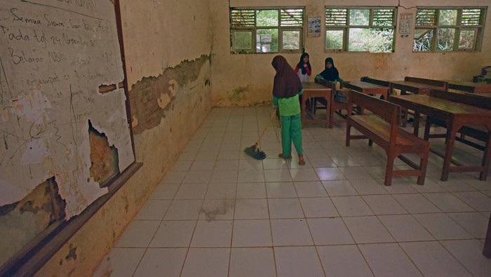 Guru dan sejumlah murid beraktivitas di ruang kelas yang rusak di SD Negeri Tanjung Ilir, Sayar, Kota Serang, Banten, Sabtu (27/5/2023). Menurut Kepala Sekolah SD tersebut, pihaknya sudah sejak tahun 2016 mengajukan permohonan perbaikan kerusakan seperti dinding yang retak, jendela pecah dan pintu bolong-bolong kepada Pemda setempat namun tak kunjung diperbaiki dengan alasan tidak ada anggaran. ANTARA FOTO/Asep Fathulrahman/foc.