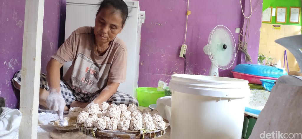 Seorang pengrajin pemoeknsedang membuat pempek.