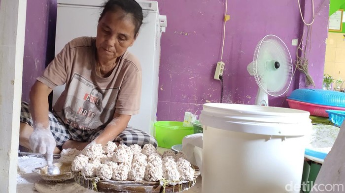 Seorang pengrajin pemoeknsedang membuat pempek