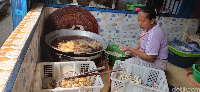 Seorang pengrajin pemoeknsedang membuat pempek