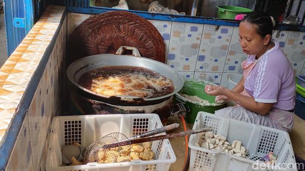 Seorang pengrajin pemoeknsedang membuat pempek