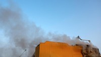Petugas Damkar berusaha memadamkan api yang membakar pabrik tembakau usai diserang drone bunuh diri. 
