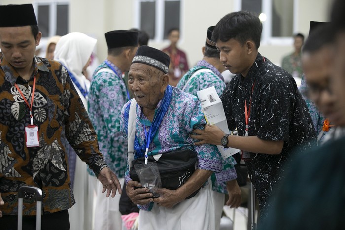 Petugas membantu jamaah calon haji untuk mengambil gelang identitas saat memasuki Asrama Haji Embarkasi Kertajati, Indramayu, Jawa Barat, Sabtu (27/5/2023) malam. Sebanyak 366 orang jamaah calon haji asal Kabupaten Majalengka masuk ke asrama haji Embarkasi Kertajati untuk diberangkatkan ke Mekah melajui bandara Kertajati pada Minggu (28/5) malam. ANTARA FOTO/Dedhez Anggara/nym.