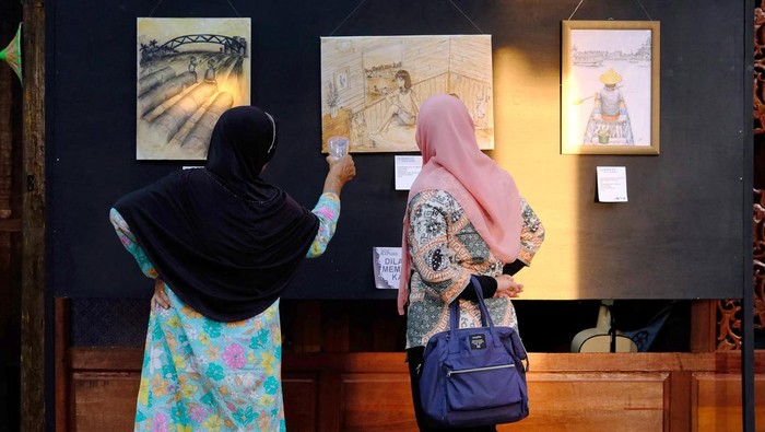 Pengunjung mengamati karya seni dalam pameran drawing bertajuk Nafas Kapuas di Rumah Cagar Budaya, Kelurahan Bansir Laut, Pontianak, Kalimantan Barat, Sabtu (27/5/2023). Pameran tersebut diikuti 40 perupa dengan menampilkan 49 gambar tentang kehidupan masyarakat di tepian Sungai Kapuas yang dibuat menggunakan pen, pensil dan crayon di atas media kertas.