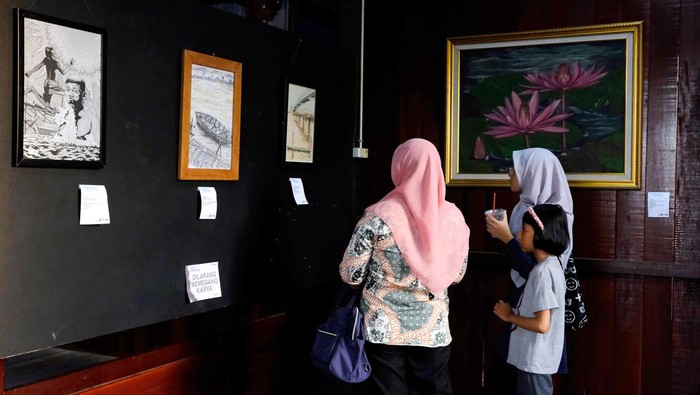 Melihat Kehidupan di Tepian Sungai Kapuas dalam Bingkai Foto Pengunjung mengamati karya seni dalam pameran drawing bertajuk Nafas Kapuas di Rumah Cagar Budaya, Kelurahan Bansir Laut, Pontianak, Kalimantan Barat, Sabtu (27/5/2023). Pameran tersebut diikuti 40 perupa dengan menampilkan 49 gambar tentang kehidupan masyarakat di tepian Sungai Kapuas yang dibuat menggunakan pen, pensil dan crayon di atas media kertas.