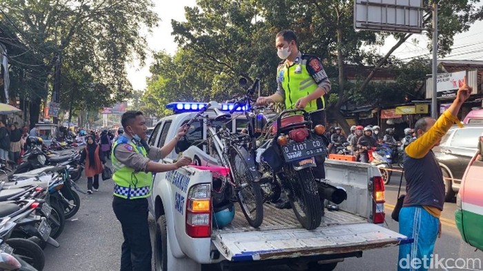 Polisi mengangkut kendaraan yang terlibat kecelakaan di Pasar Cihaurgeulis, Kota Bandung