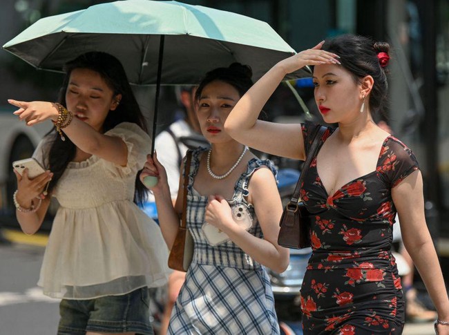 Women use an umbrella to shelter from the sun amid hot weather in Shanghai on May 29, 2023. Shanghai on May 29 recorded its hottest May day in 100 years, the citys meteorological service announced, shattering the previous high by a full degree. (Photo by AFP) / China OUT (Photo by STR/AFP via Getty Images)
