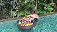 Waktu bersantai tak pernah dilewatkan oleh Angela Lee tanpa floating breakfast. Ditemani suasana alam yang asri, ia asyik makan omelette hingga buah-buahan. Foto: Instagram/angelalee87