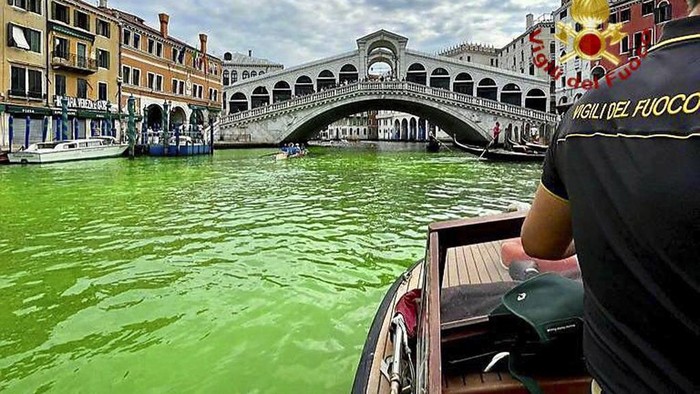 Kanal di Venesia Mendadak Berubah Hijau Gondolas navigate by the Rialto Bridge on Venice's historical Grand Canal as a patch of phosphorescent green liquid spreads in it, Sunday, May 28, 2023. The governor of the Veneto region, Luca Zaia, said that officials had requested the police to investigate to determine who was responsible, as environmental authorities were also testing the water. (AP Photo/Luigi Costantini)