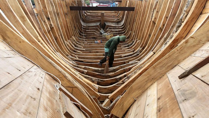 Menengok 'Pabrik' Galangan Kapal Punya Nelayan Pekerja menyelesaikan pembuatan kapal untuk kebutuhan nelayan di galangan tradisional kapal kayu, Banda Aceh, Aceh, Senin (29/5/2023). Pelaku industri galangan kapal kayu berharap adanya regulasi khusus terhadap proses perbaikan dan pembuatan baru kapal kayu untuk nelayan yang masih terkendala bahan baku kayu sejak berlakunya moratorium logging (jeda tebang) yang dikeluarkan Pemerintah Aceh pada pertengahan 2007. ANTARA FOTO/Irwansyah Putra/foc.